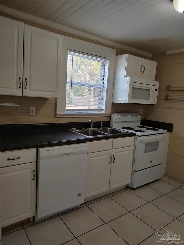 kitchen featuring sink, white cabinets, light tile patterned floors, wooden ceiling, and white appliances