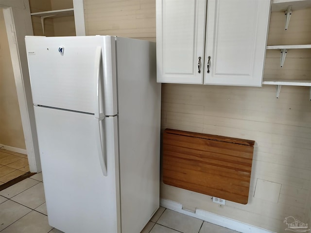 kitchen featuring white cabinetry, white fridge, and light tile patterned floors