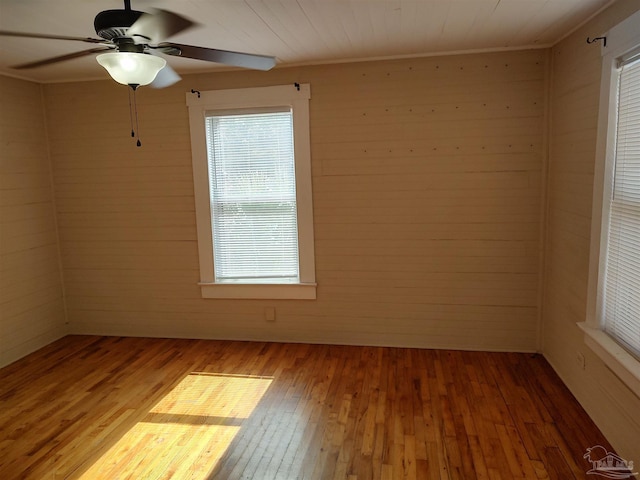 spare room featuring hardwood / wood-style flooring, ceiling fan, and ornamental molding