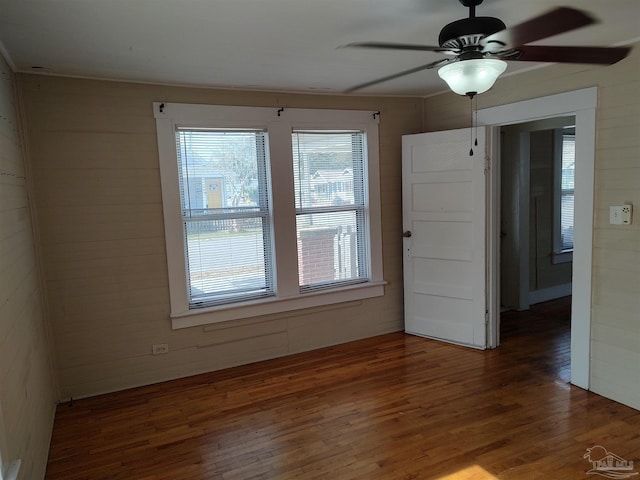 empty room with dark wood-type flooring and ceiling fan