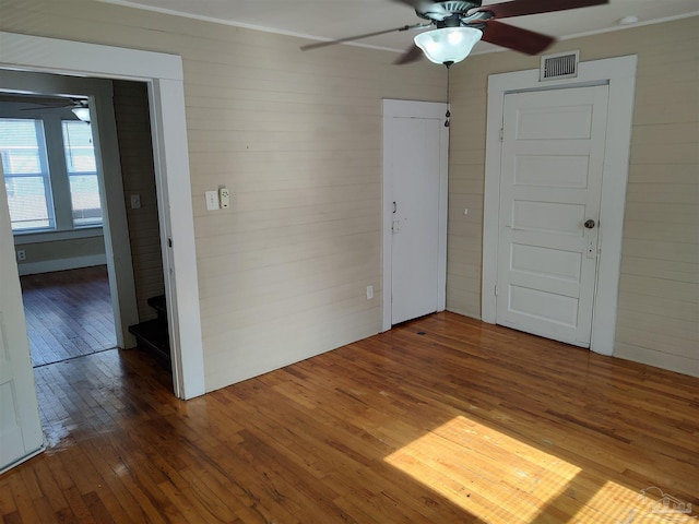 empty room with ceiling fan and dark hardwood / wood-style floors