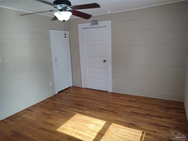 empty room with dark wood-type flooring and crown molding