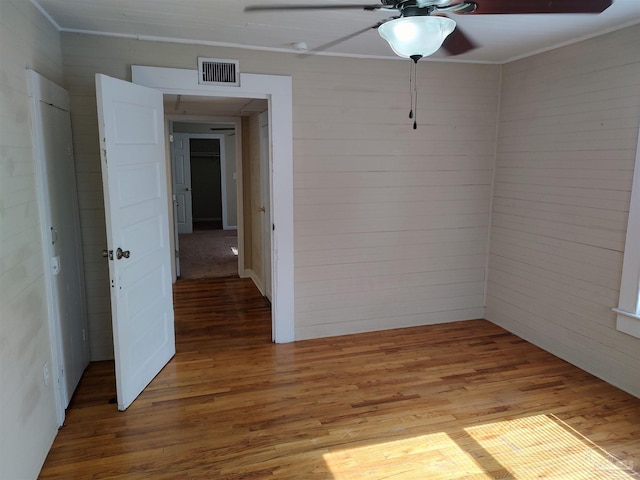 spare room with ceiling fan, ornamental molding, and wood-type flooring