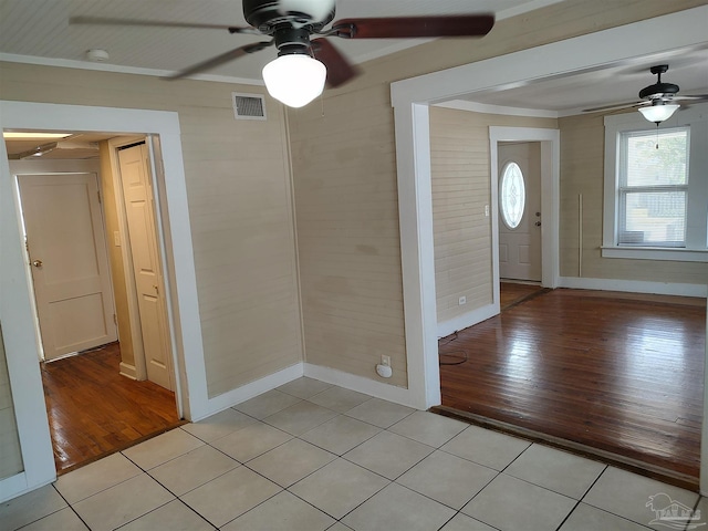 tiled foyer entrance featuring ornamental molding and ceiling fan