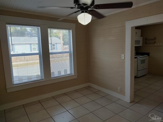 unfurnished dining area featuring plenty of natural light, ceiling fan, and light tile patterned flooring