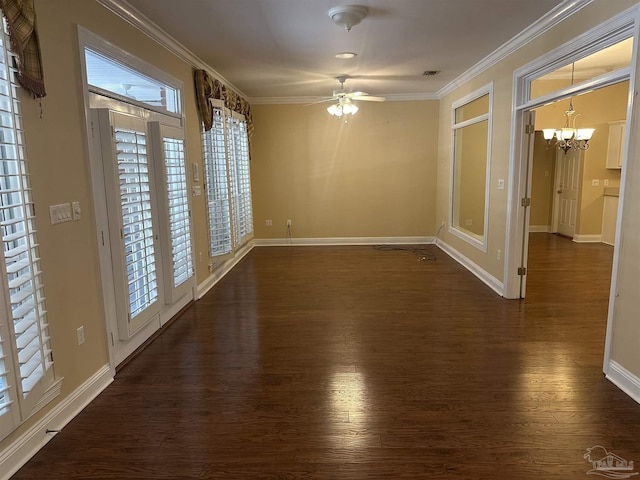 spare room with ceiling fan with notable chandelier, dark wood-type flooring, visible vents, baseboards, and ornamental molding