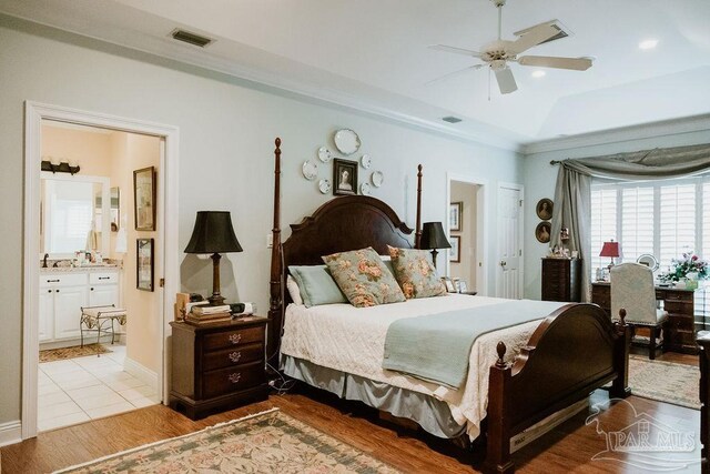 bedroom featuring light hardwood / wood-style flooring, ceiling fan, and ensuite bath