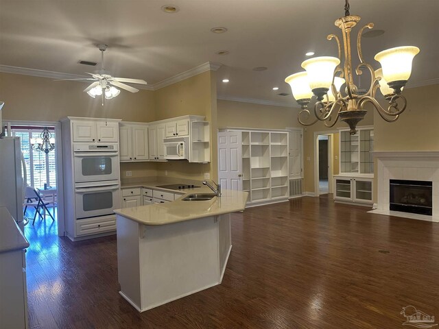 kitchen featuring white appliances, dark wood-style flooring, a fireplace, white cabinets, and open floor plan