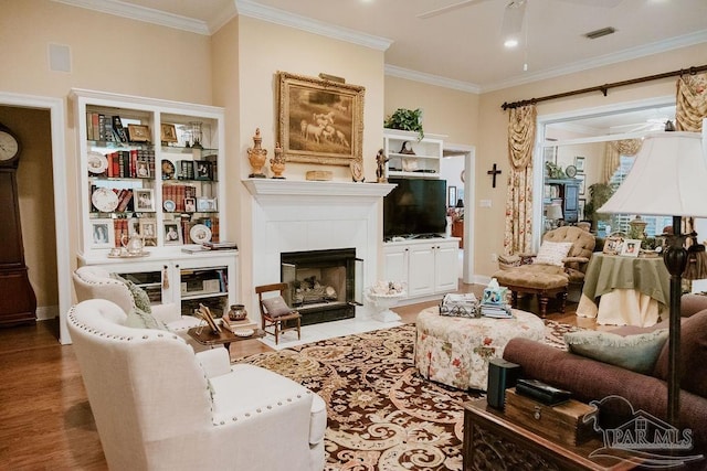 living area with ornamental molding, visible vents, and a tiled fireplace