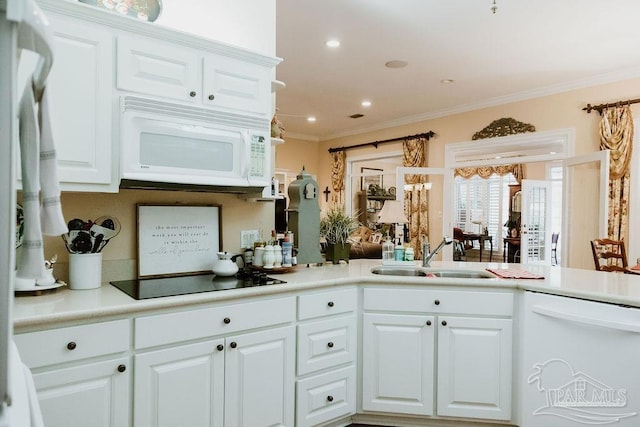 kitchen featuring white appliances, a sink, white cabinetry, and crown molding