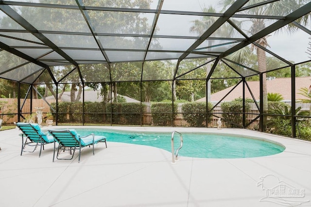 view of swimming pool featuring a patio area and glass enclosure