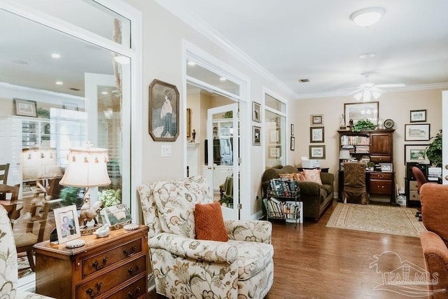 living room with ornamental molding, a ceiling fan, visible vents, and dark wood-style floors