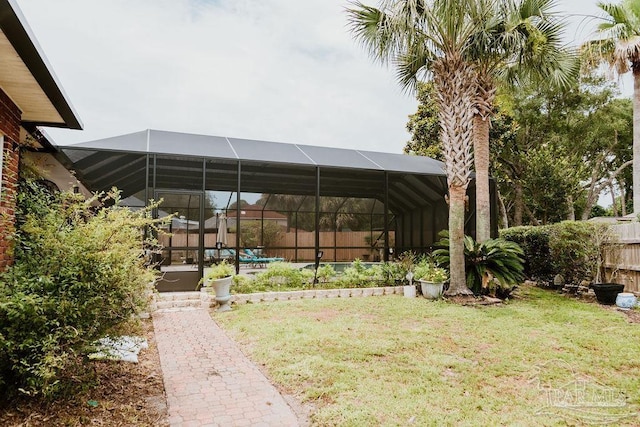 view of yard featuring a pool, glass enclosure, and fence