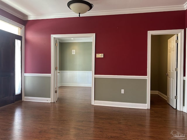 empty room with ornamental molding, wood finished floors, and baseboards