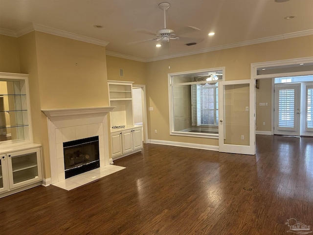 unfurnished living room with french doors, a fireplace, ornamental molding, wood finished floors, and baseboards