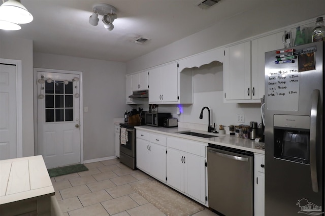 kitchen with stainless steel appliances, white cabinetry, and sink