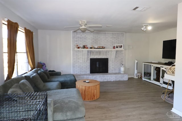 living room with ceiling fan, hardwood / wood-style floors, and a fireplace