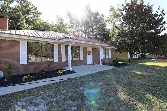 ranch-style home with a front yard and a patio area