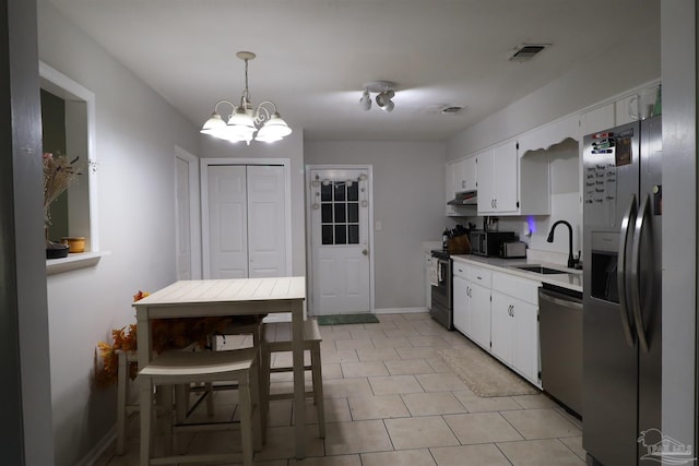 kitchen with decorative light fixtures, white cabinetry, stainless steel appliances, sink, and a chandelier