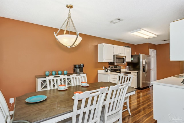 dining space with dark hardwood / wood-style flooring