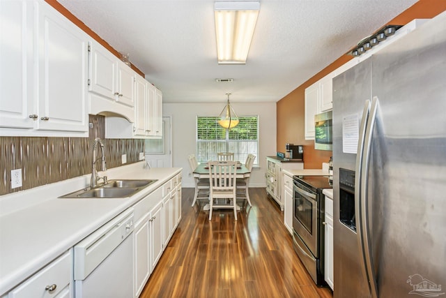 kitchen featuring white cabinetry, dark hardwood / wood-style flooring, pendant lighting, sink, and appliances with stainless steel finishes