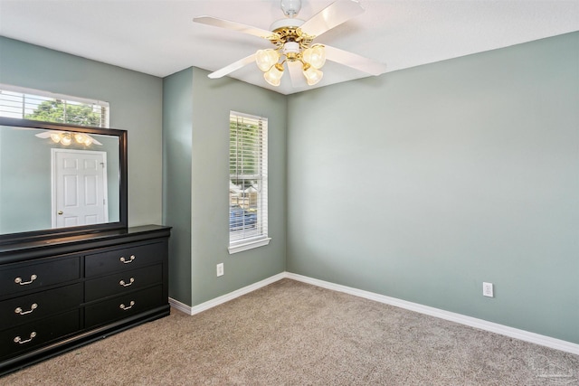 unfurnished bedroom with multiple windows, ceiling fan, and light colored carpet