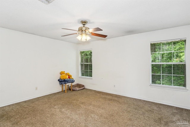 empty room featuring carpet, ceiling fan, and plenty of natural light