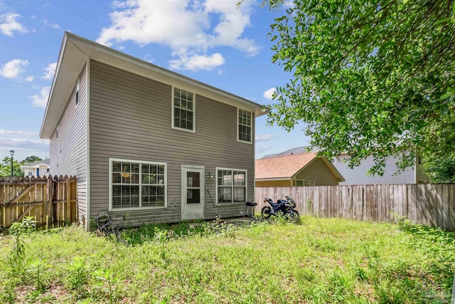 rear view of house featuring a lawn