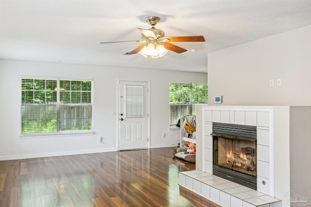 living room featuring a fireplace, wood-type flooring, and ceiling fan