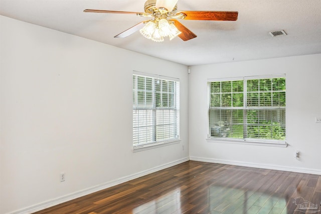 unfurnished room featuring dark wood-type flooring, ceiling fan, and a healthy amount of sunlight