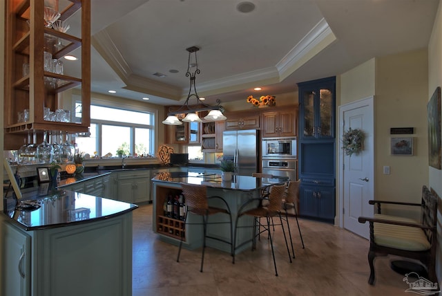 kitchen with dark countertops, a tray ceiling, stainless steel appliances, and glass insert cabinets