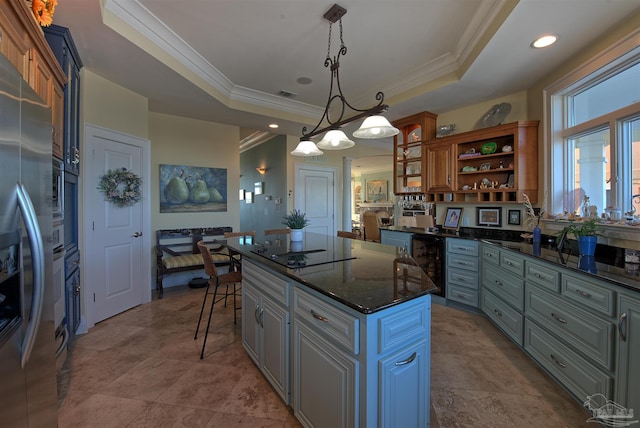 kitchen featuring wine cooler, a center island, open shelves, a tray ceiling, and decorative light fixtures