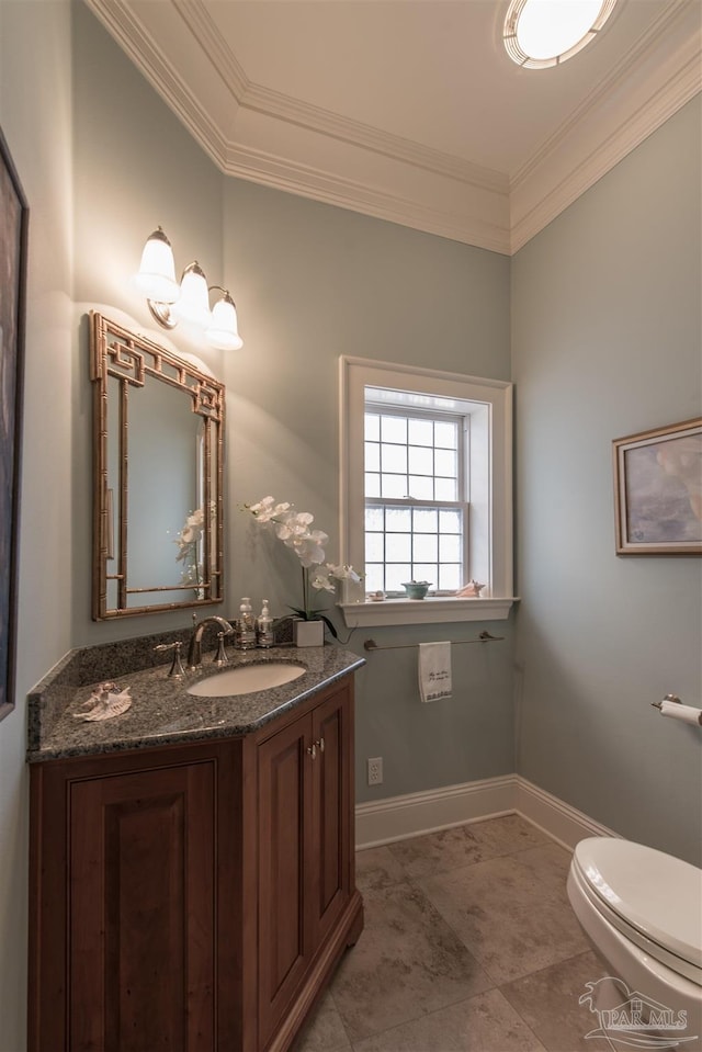 bathroom with baseboards, toilet, vanity, and crown molding