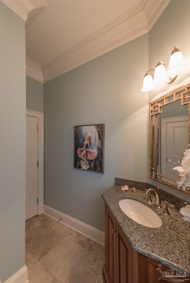 bathroom with ornamental molding, vanity, and baseboards