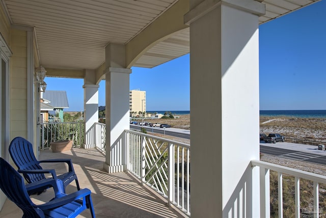 balcony featuring a beach view and a water view