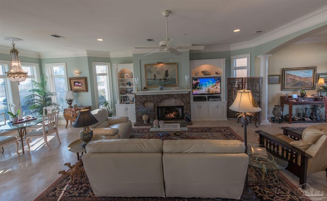 living area featuring arched walkways, a premium fireplace, visible vents, built in features, and decorative columns