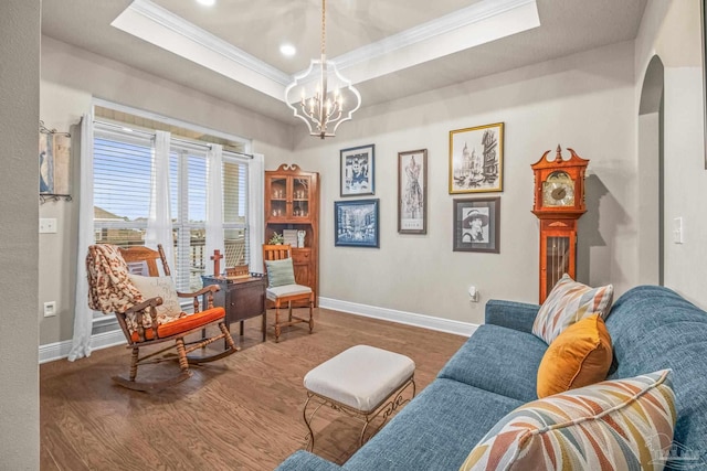 sitting room featuring wood finished floors, ornamental molding, a raised ceiling, and baseboards