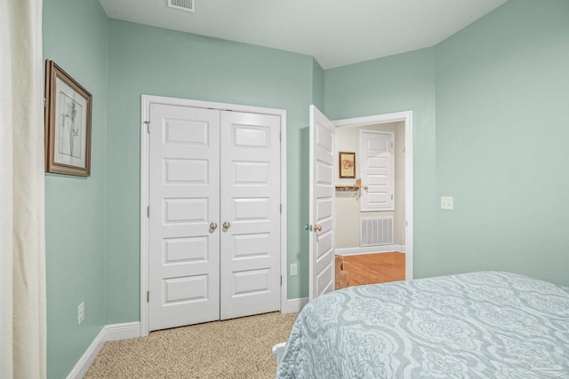 bedroom featuring light colored carpet, a closet, visible vents, and baseboards