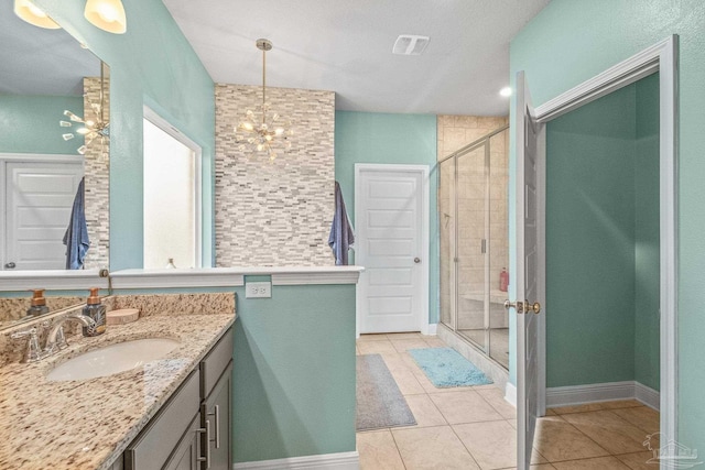 full bathroom with tile patterned flooring, a notable chandelier, vanity, visible vents, and a shower stall