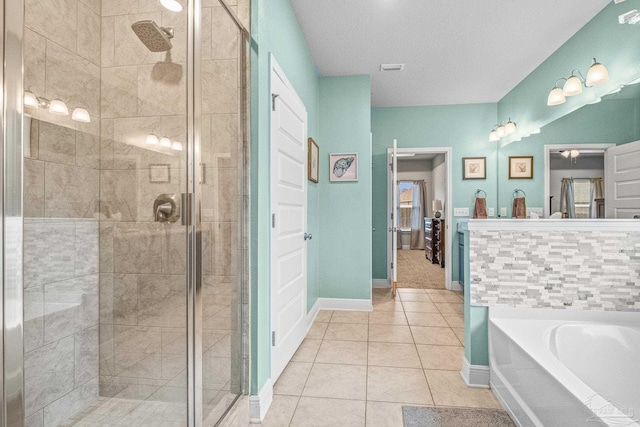 bathroom with a stall shower, tile patterned flooring, baseboards, and a garden tub