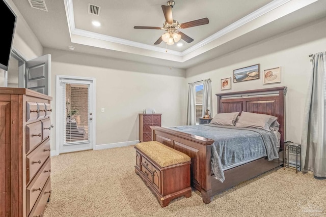 bedroom with a tray ceiling, visible vents, crown molding, and baseboards