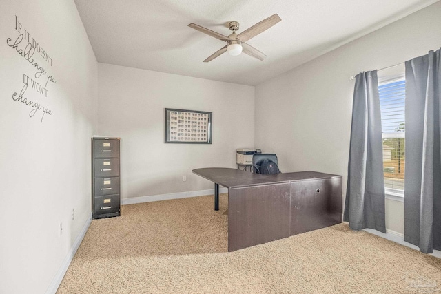 carpeted office with a ceiling fan and baseboards