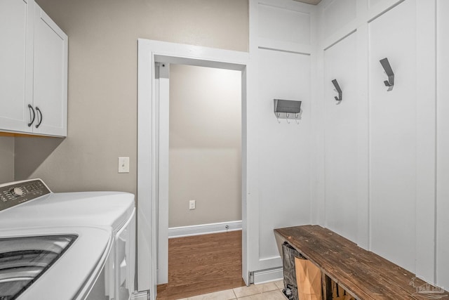 laundry area with cabinet space, washer and clothes dryer, and light tile patterned flooring