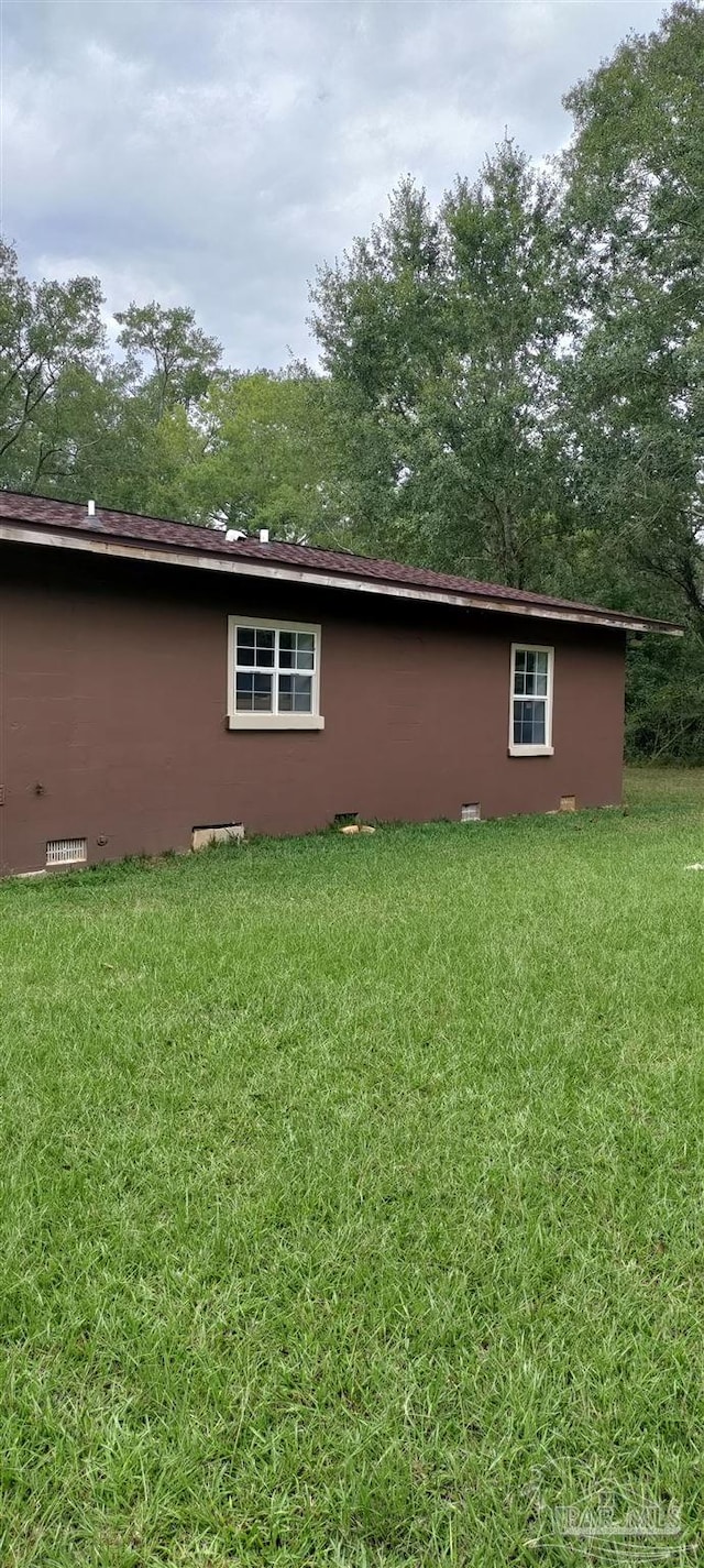 rear view of property featuring a lawn