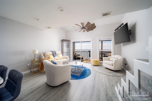 living area featuring visible vents, baseboards, and wood finished floors