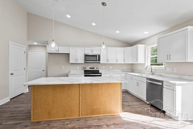 kitchen with pendant lighting, sink, a kitchen island, white cabinetry, and stainless steel appliances