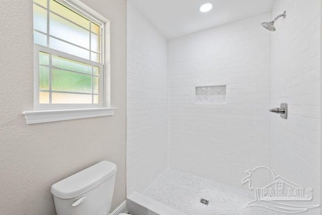 bathroom with toilet and tiled shower