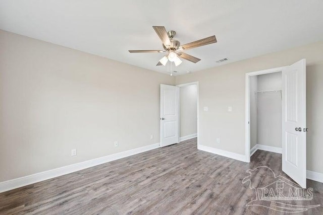 unfurnished bedroom with hardwood / wood-style flooring, ceiling fan, and a closet