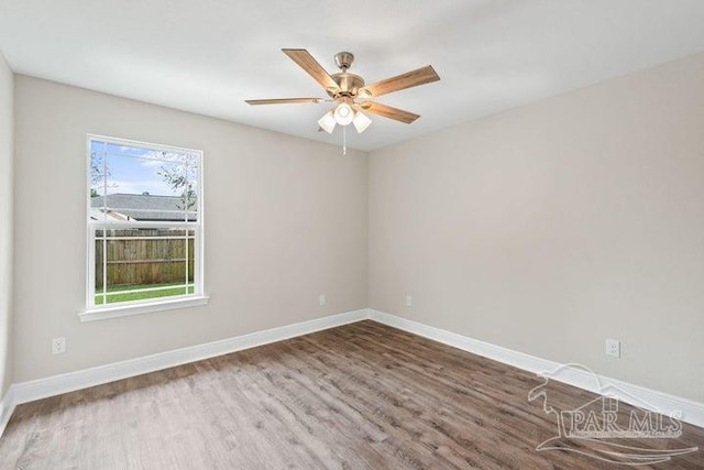 unfurnished room featuring a wealth of natural light, ceiling fan, and dark wood-type flooring