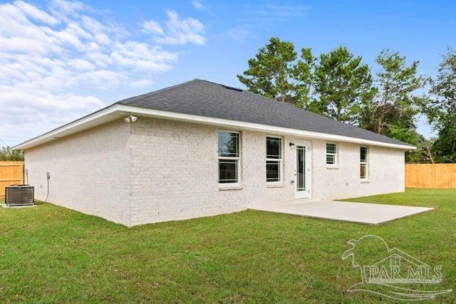 rear view of house featuring a lawn, a patio area, and central AC unit